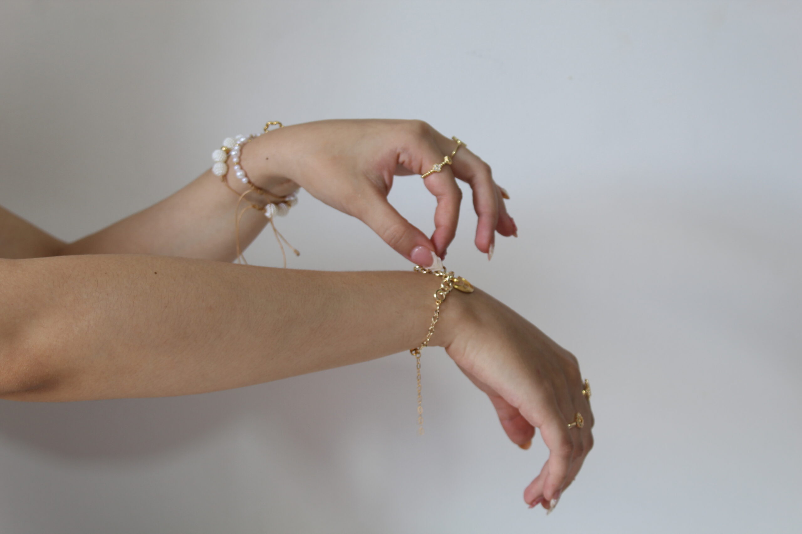 Pulseras demostradas en la mano de una mujer echas en oro golfi con mucho amor
