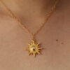 Cadena en forma de sol hecha en oro golfi expuesta en el cuello de una hermosa mujer