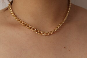Cadena sencilla hecha en oro golfi expuesta en el cuello de una hermosa mujer