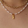 cadena_virgencita Cadena con dije de virgencita hecho en oro golfi expuesta por el cuello de una hermosa mujer