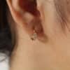 aretes_encanto Aretes para mujer hechos en oro golfi con perlas brillantes expuestos en la oreja de una hermosa mujer