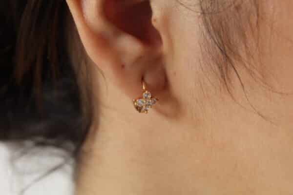 aretes_encanto Aretes para mujer hechos en oro golfi con perlas brillantes expuestos en la oreja de una hermosa mujer