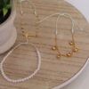 Son 3 pulseras expuestas en una mesa con una flor las cuales son echas en oro golfi muy delicadas