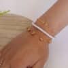 Pulseras para otoño hechas en oro golfi expuestas en la mano de una hermosa mujer